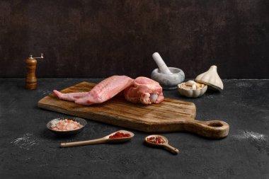 Ahşap kesme tahtasının üzerinde çiğ hindi kanadı