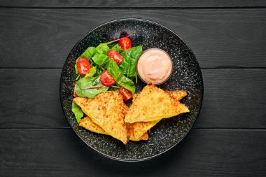 Erimiş çedar peyniri ve tabakta salata ile sandviçin genel görünümü