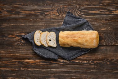 Kahverengi ahşap masada taze pişmiş ciabatta.
