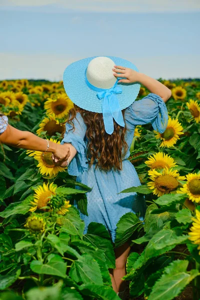 Žena Modrých Šatech Širokém Klobouku Drží Přítelovu Ruku Která Běží — Stock fotografie