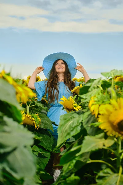 Žena Modrých Nebeských Šatech Drží Okraje Slaměného Klobouku Dívá Nahoru — Stock fotografie