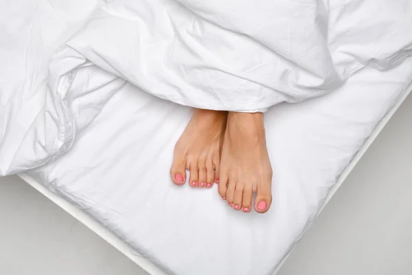 Bovenaanzicht Van Vrouwelijke Tenen Steken Uit Van Onder Deken Bed — Stockfoto