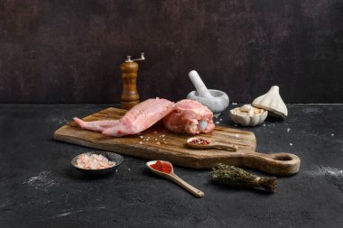 Ahşap kesme tahtasının üzerinde çiğ hindi kanadı