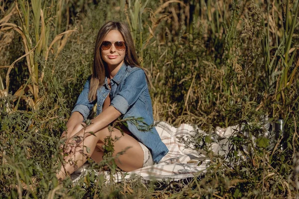 Aantrekkelijk meisje zit in het veld met boek — Stockfoto