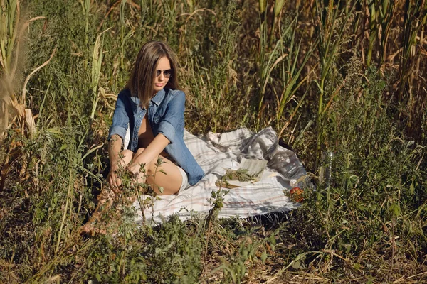 Menina atraente sentado no campo com livro — Fotografia de Stock