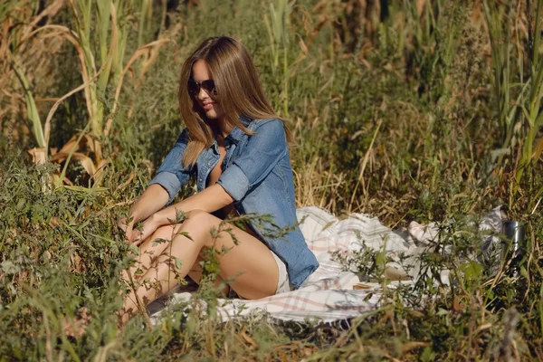 Aantrekkelijk meisje zit in het veld met boek — Stockfoto