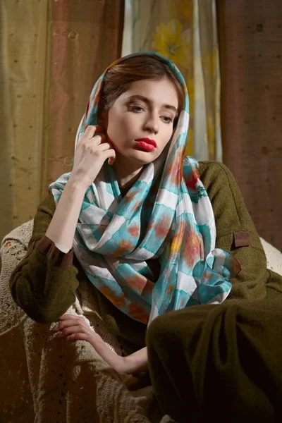 Signora in camera scura seduta in poltrona in abito di lana e sciarpa di seta — Foto Stock