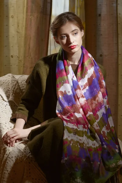 Señora en habitación oscura sentada en sillón en vestido de lana y bufanda de seda — Foto de Stock