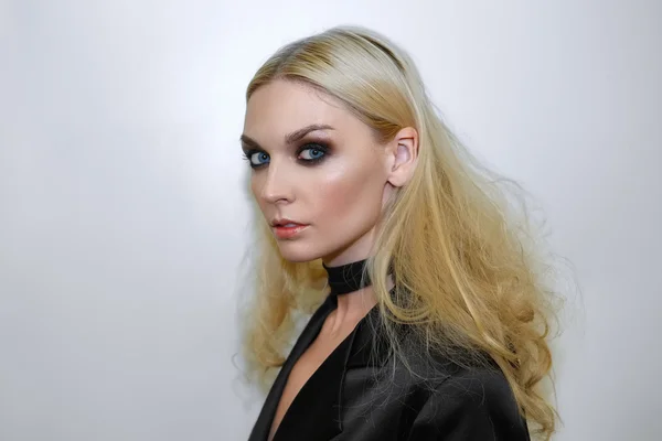 Blonde dame in zwarte jas en donkere make-up — Stockfoto