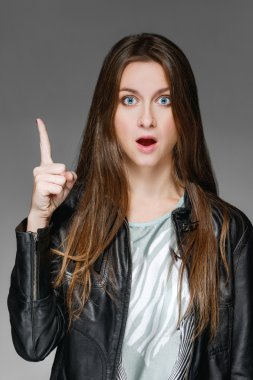 Genç Bayan deri ceketli bir parmağını gösterir ve bir söylüyor