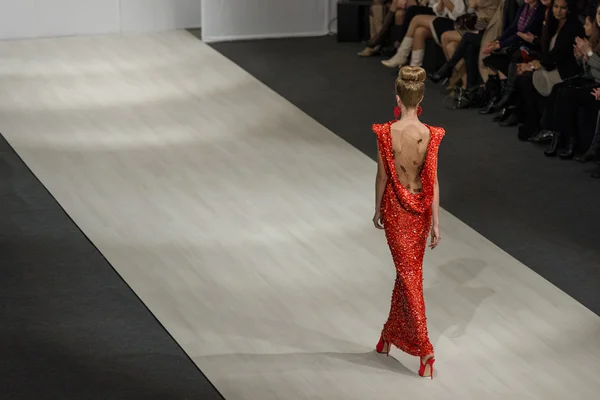 Model v červených šatech na dráze týden módy — Stock fotografie