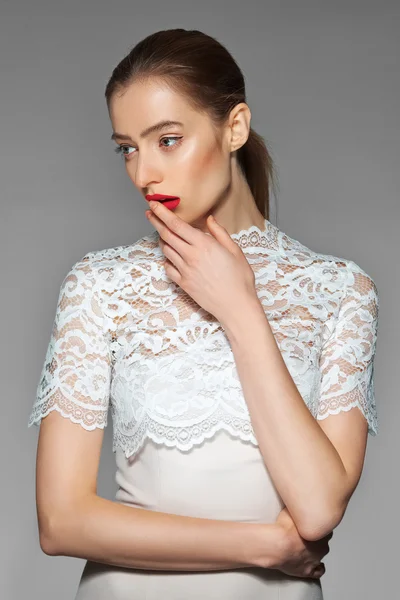 Magnifique mariée en robe blanc perle regardant sur le côté et touchant ses lèvres rouges — Photo