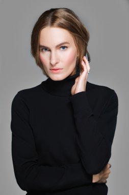 güzel kız kendini sarılma ve saçlarını dokunaklı siyah kazak