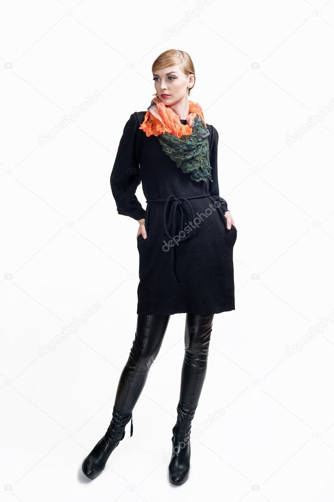 attractive woman in short black dress and high leather boots with scarf posing