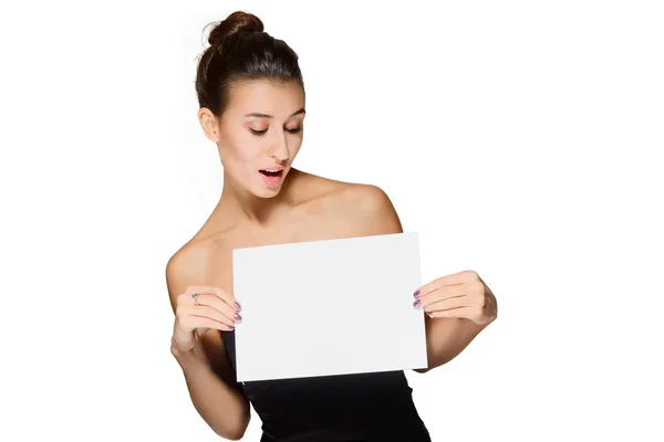 Jovem senhora segurando folha de papel em branco e olhando para ele — Fotografia de Stock