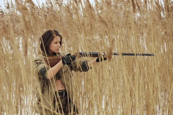 Bonita chica en camuflaje con rifle — Foto de Stock