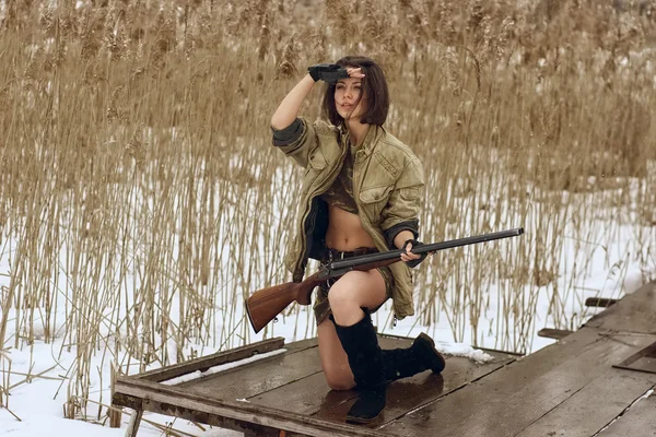 Bonita chica con rifle de caza mirando hacia adelante — Foto de Stock