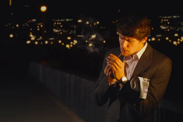 Homme en costume obtenir une lumière une cigarette sur un pont — Photo