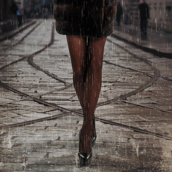 female legs under the rain on the street