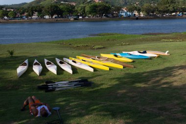 Flix, Bahia, Brezilya - 29 Eylül 2018. Adam, tarihi So Fliz şehrindeki Paraguau Nehri 'nde seyrüsefer için birkaç farklı renkli kanonun yanında dinleniyor..
