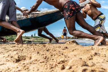 Salvador, Bahia, Brezilya - 23 Mayıs 2021: Balıkçılar kanolarını denizden Rio balıkçı kolonisine götürüyorlar.