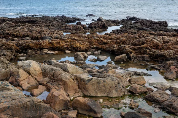 Mavi Gökyüzü Deniz Kayaların Üzerinde Kumsalda Kum Dalgalar Kayalara Çarpıyor Stok Fotoğraf