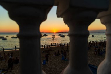 Blaustrade. Sahilde bir sürü insanla gün batımı..