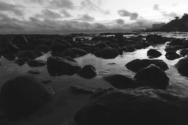 海と岩の上のビーチで劇的な夕日 反射は風景を美しくするように見えます — ストック写真