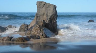 Güçlü, güneşli bir günde Farol da Barra sahilindeki kayalıklarda okyanus dalgaları kırılıyor. Salvador Bahia Brezilya.