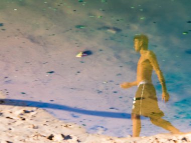 Salvador, Bahia, Brezilya - 02 Ocak 2019: Ondina sahilindeki su birikintisinde bir insanın yansıması.