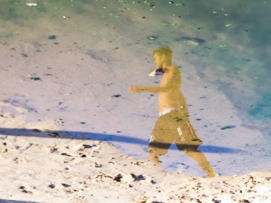 Salvador, Bahia, Brezilya - 02 Ocak 2019: Ondina sahilindeki su birikintisinde bir insanın yansıması.