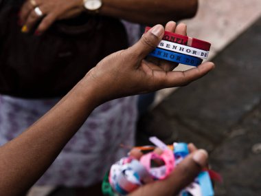 Bir rulo Sinyor Bonfim kurdelesi tutan eller. Her zaman yılın son cuma günü, Igreja do Senhor do Bonfim, Salvador, Bahia, Brezilya 'da ayinler düzenlenir..