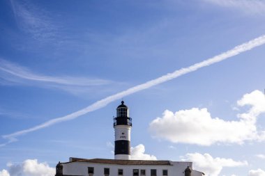 Salvador, Bahia, Brezilya - 08 Ağustos 2021: Ünlü Farol da Barra üzerinde parlak mavi gökyüzü. Dünyanın dört bir yanından gelen turistler tarafından ziyaret edilen çok kişi var. Şehrin gerçek bir kartpostalı..