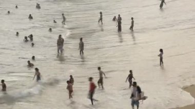 Salvador, Bahia, Brezilya - 22 Ağustos 2021: Rio Vermelho mahallesindeki kalabalık Pacincia plajında insanlar atlıyor.