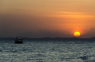 Güzel, sarı ve turuncu gün batımı dağların arkasına düşüyor. Salvador, Bahia, Brezilya.