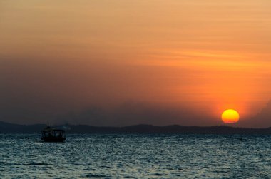 Güzel, sarı ve turuncu gün batımı dağların arkasına düşüyor. Salvador, Bahia, Brezilya.