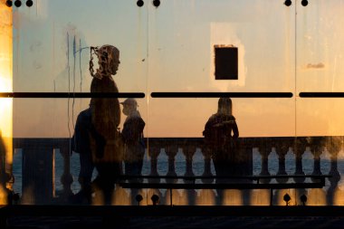 Salvador, Bahia, Brezilya - 17 Haziran 2021: Ağaç günbatımında siluet, otobüs durağı ve Porto da Barra 'nın kenarında yürüyen insanlar.