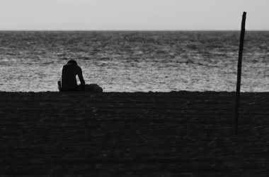 Salvador, Bahia, Brezilya - 29 Ekim 2015: Salvador, Bahia 'daki Ribeira plajında günbatımının keyfini çıkaran insanların silueti.