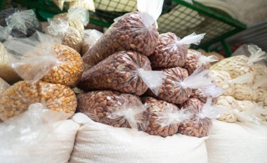 Canlı bir pazarda açık plastik poşetlere doldurulmuş badem ve fıstık sergilenir. Müşteriler için güzelce istiflenir.. 