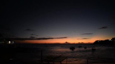 Rio Vermelho Sahili 'nin dramatik gün batımı manzarası ve demirli balıkçı tekneleri. Salvador, Bahia.