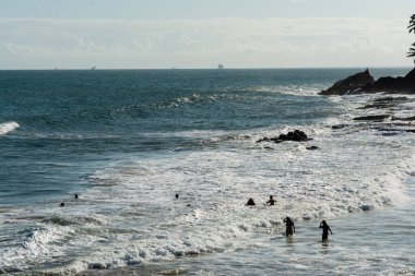 İnsanlar, Salvador, Bahia 'daki Paciencia Plajı' nda bir öğleden sonra denizin ve dalgaların gücünün tadını çıkarırken görülüyor.