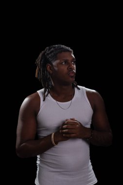 Rasta bukleli ve beyaz gömlekli yakışıklı bir genç fotoğraf çekimi sırasında yan tarafa bakıyor. Dumanlı bir arka planda izole edilmiş. Fotoğraf modeli