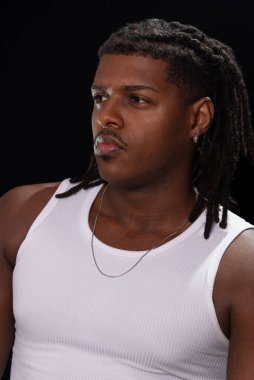 Rasta bukleli ve beyaz gömlekli yakışıklı bir genç fotoğraf çekimi sırasında yan tarafa bakıyor. Dumanlı bir arka planda izole edilmiş. Fotoğraf modeli