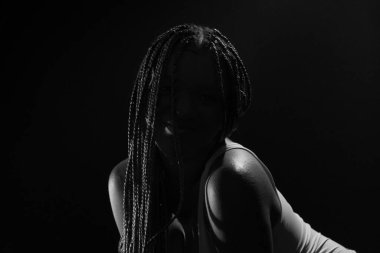 Bir fotoğraf için poz veren siluetli bir kadının siyah beyaz portresi. Siyah bir arka planda izole edilmiş. Fotoğraf çekimi..