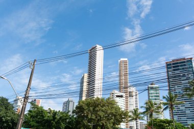 Salvador, Bahia, Brezilya - 6 Ağustos 2025: Salvador, Bahia 'da açık mavi gökyüzü altında birkaç yüksek gökdelenin taban manzarası.