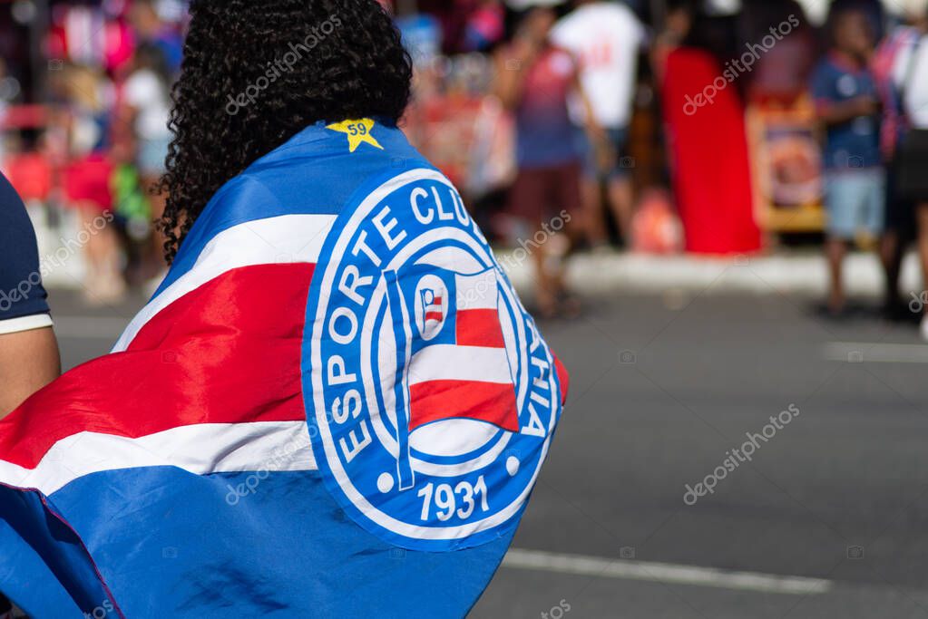 Salvador, Bahia, Brazil - November 2, 2025: Fans of Esporte Clube Bahia are seen with flags wrapped around their bodies for a Brazilian championship game. Salvador, Brazil.