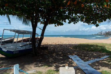 Salvador, Bahia, Brezilya - 2 Kasım 2025: Rio Vermelho Sahili 'ndeki şehir ufkunun önündeki rustik balıkçı teknelerinin görüntüsü. Bahia, Salvador şehri..