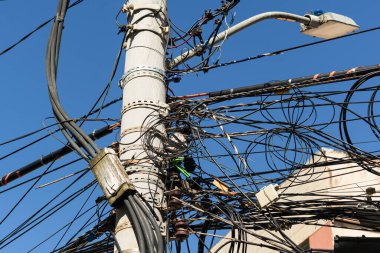 Salvador, Bahia, Brezilya - 3 Ağustos 2025: Salvador, Bahia 'da mavi bir gökyüzü altında kablolar ve izolatörlerle bir elektrik direğinin görüntüsü.