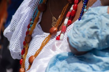 Salvador, Bahia, Brezilya - 25 Kasım 2025: Pelourinho, Salvador, Bahia 'daki günlerine katılan Baiana do Acaraje' nin vücut ve giysilerinin ayrıntıları.