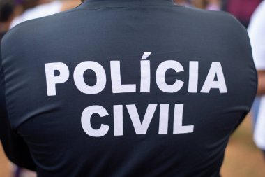 Bir polis memurunun siyah tişörtünün arkası. Beyaz harflerle POLiCIA CIVIL yazılıydı. Salvador, Bahia 'da feministlere karşı bir protesto sırasında..